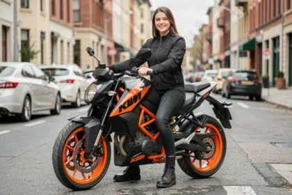 Petite pilote assise sur une KTM Duke 125 2026 avec les deux pieds à plat au sol en milieu urbain