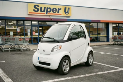 Voiture sans permis blanche garée devant un supermarché Super U en France